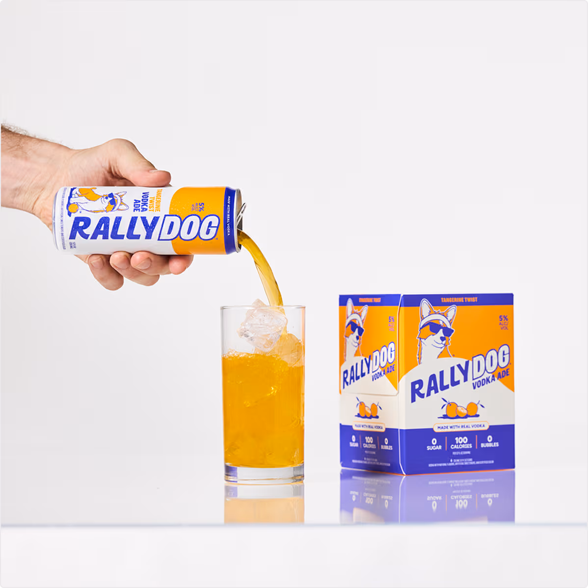 A hand pouring Rally Dog Tangerine Twist Vodka Ade into a glass